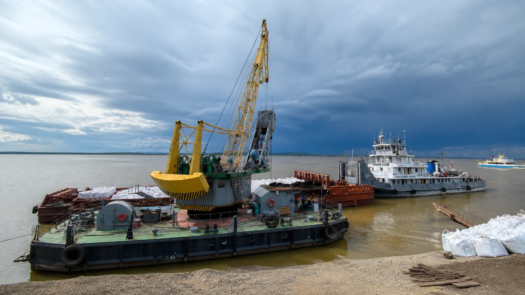 Плавучий портовый кран и суда во время погрузочных работ